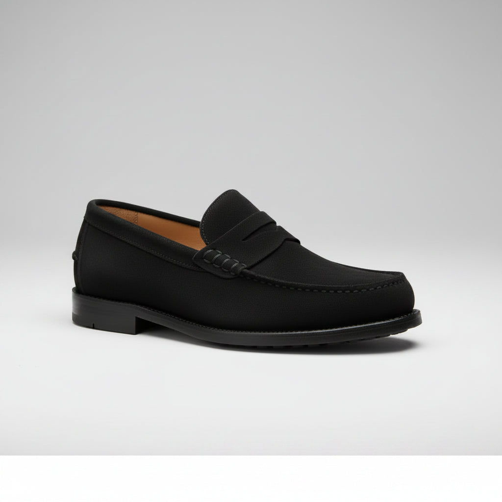 Black loafers worn by a person with a neutral background